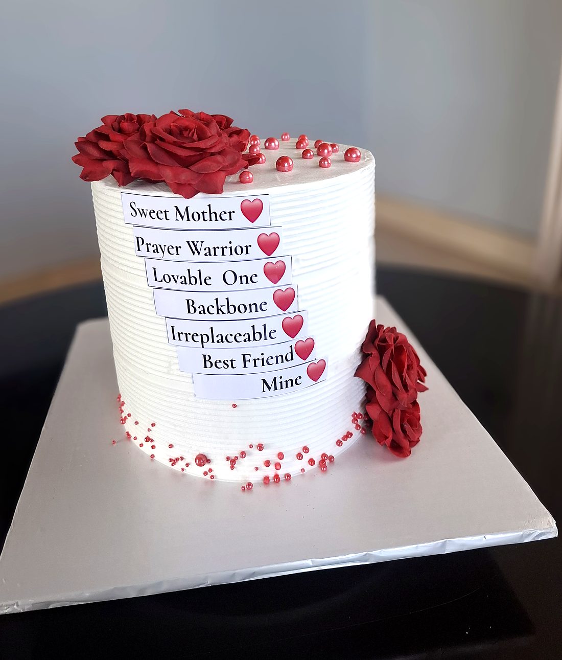Tall white ribbed buttercream cake with red sugar roses and Sweet Mother, Prayer Warrior, Best Friend tags